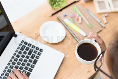 woman drink coffee and use laptop computer on desk | Stock image | Colourbox