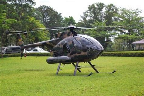 a helicopter sitting on top of a lush green field