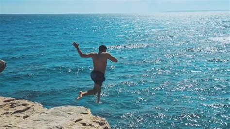 Man Jumping Off Cliff - Stock Video | Motion Array