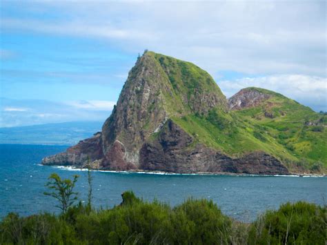 an island in the middle of the ocean surrounded by greenery and blue ...