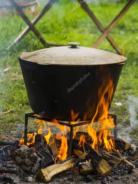 Food in a cauldron on a fire. Cooking outdoors in cast-iron cauldron ...