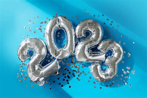 Premium Photo | Silver numbers 2023 new year balloons in sunlight blue background