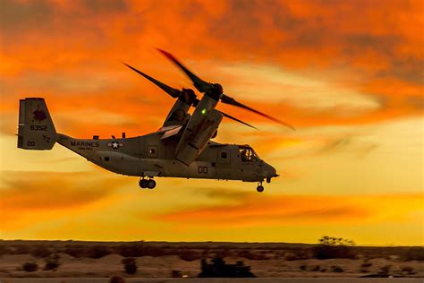 A Marine Corps MV-22 Osprey tiltrotor aircraft hovers over the desert before departing from ...