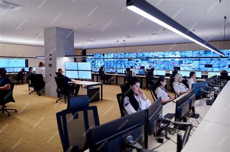 Premium Photo | Group of Security data center operators working in a CCTV monitoring room ...