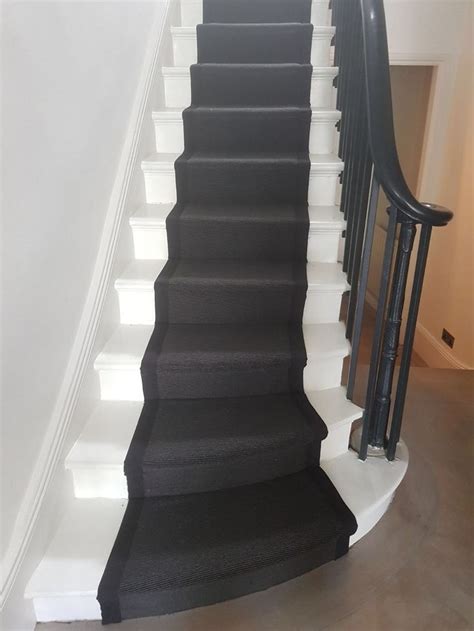 a black and white staircase leading up to a second floor room with ...