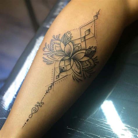 a woman's leg with a flower tattoo on the side of her leg and an arrow