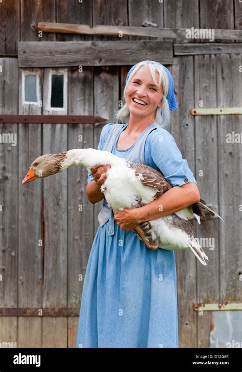 Germany, Bavaria, Mature woman with goose on farm Stock Photo - Alamy