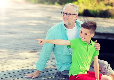 Premium Photo | Grandfather and grandson sitting on river berth