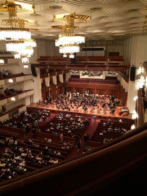 an auditorium filled with people and chandeliers