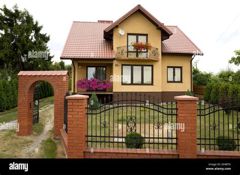 Modern Polish house with wrought iron fence with brick pillars and arch ...