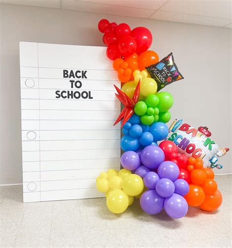 there is a bunch of balloons in front of the back to school sign