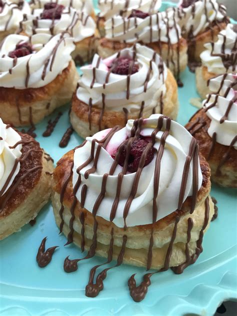 many pastries with chocolate drizzled on them sitting on a blue plate