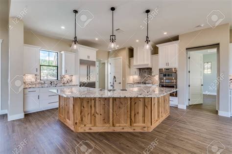 Newly finished angled kitchen island with natural wood look and quartz ...