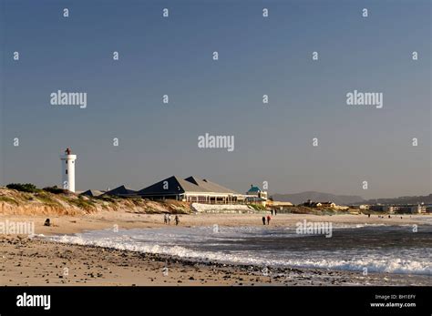 milnerton lighthouse and beach at dusk cape town south africa people walking on the beach Stock ...