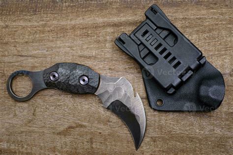 Karambit knife tactical fighter on wood background 7986509 Stock Photo at Vecteezy