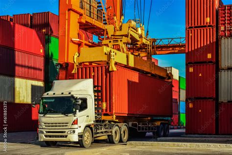 Container truck or Rubber Tired Gantry Cranes (RTG) picking up a container at yard. Port ...