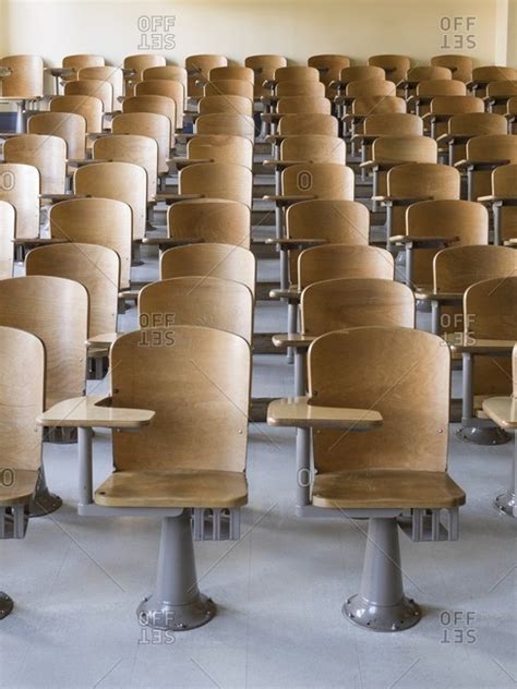 Rows of desks in classroom stock photo - OFFSET