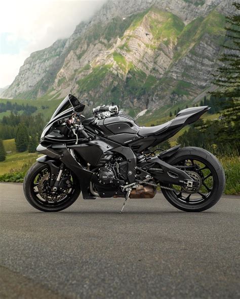 the motorcycle is parked on the side of the road in front of a mountain ...