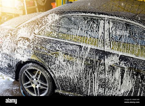 Wash the black car with foam at the car wash station Stock Photo - Alamy