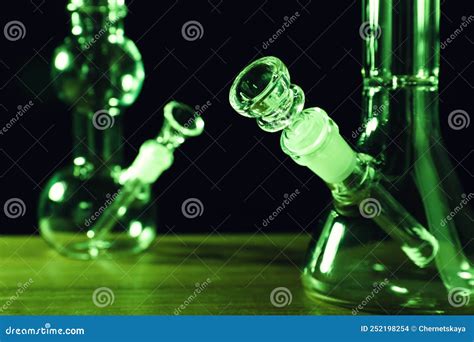 Glass Bongs on Wooden Table Against Black Background, Toned in Green. Smoking Device Stock Photo ...