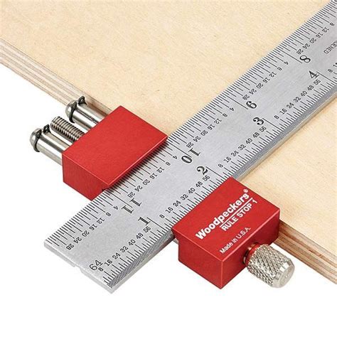 a wooden ruler with two red cubes and a screwdriver on the side