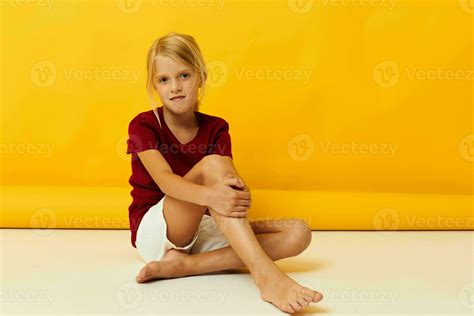 little girl sitting on the floor posing in casual clothes 25002291 Stock Photo at Vecteezy