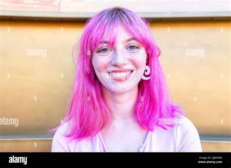 close up portrait of alternative woman withpink hair hanging out chilling and smiling standing ...