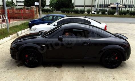 a black sports car parked next to two white cars