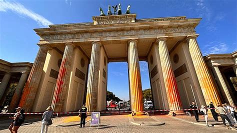 Activists spray the Brandenburg Gate orange as global protests call for end of fossil fuels ...