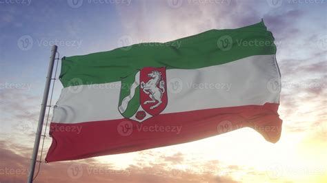 North Rhine-Westphalia flag, Germany, waving in the wind, sky and sun background. 3d ...