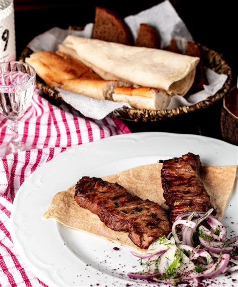 Free Photo | Azerbaijani traditional kebab, barbeque in lavash with sumakh, onion and green salad.