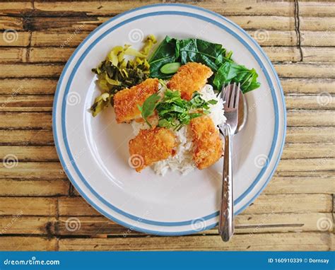 Steamed Rice Topped with Fried Crispy Fish Placed on a Bamboo Table ...