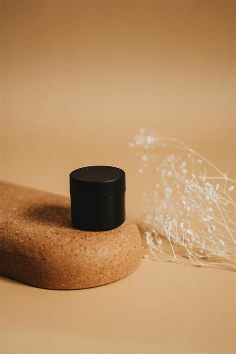 Black Plastic Bottle on Brown Round Table · Free Stock Photo