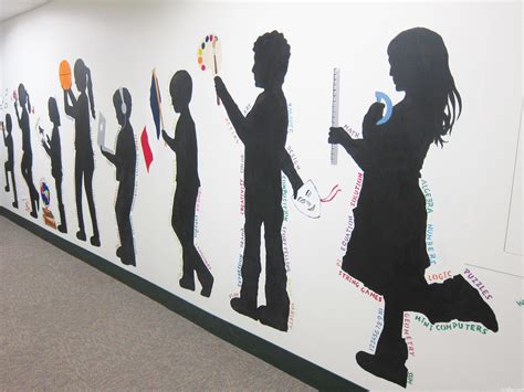 a wall with many silhouettes of people on it