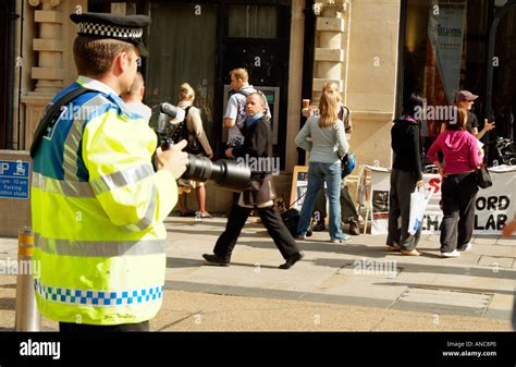 Uniformed police officer using a digital camera to photograph animal ...