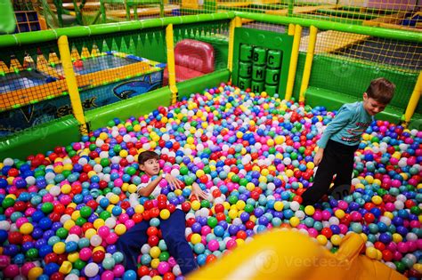 Child playing in colorful ball pit. Day care indoor playground. Balls ...