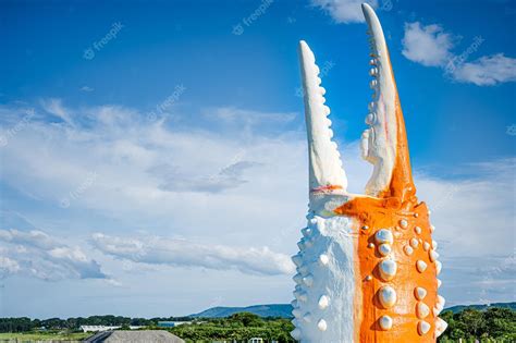 Premium Photo | A giant orange monster sculpture with a blue sky in the ...