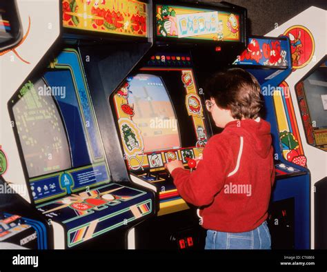 Boy playing vintage video arcade games Stock Photo - Alamy