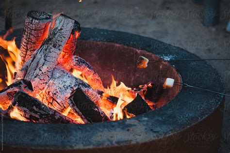 "Two Marshmallows Being Roasted Over A Campfire" by Stocksy Contributor "Amanda Worrall" - Stocksy