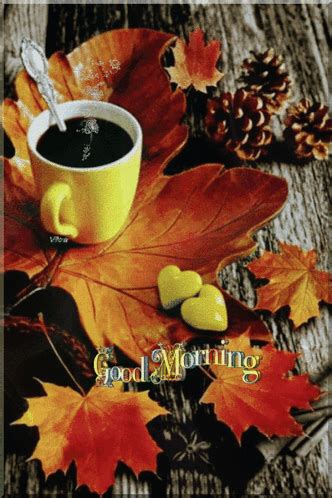 a cup of coffee sitting on top of a wooden table next to leaves and acorns