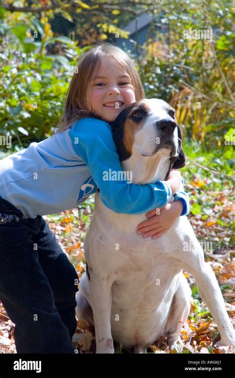 Little girl giving her hound dog a big hug Stock Photo - Alamy