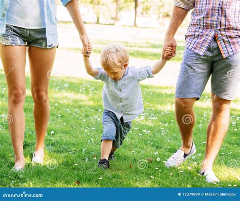 Handsome Toddler Having a Walk with Parents Holding Their Hands Stock ...