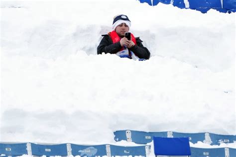 Fans attending Pittsburgh Steelers vs. Buffalo Bills NFL playoff game digging for their seats in ...