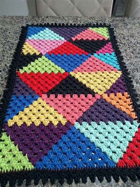 a multicolored crocheted blanket sitting on top of a gray countertop