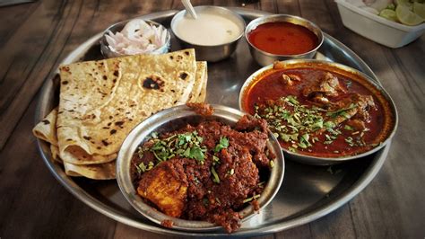 [I ate] Indian thali (Plate) with chicken masala and chicken gravy along with breads and salad ...