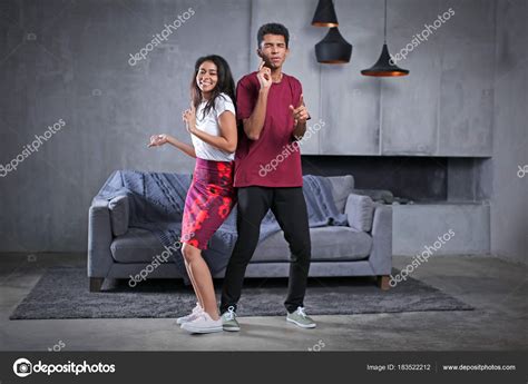 Attractive African-American couple dancing at home Stock Photo by ©belchonock 183522212