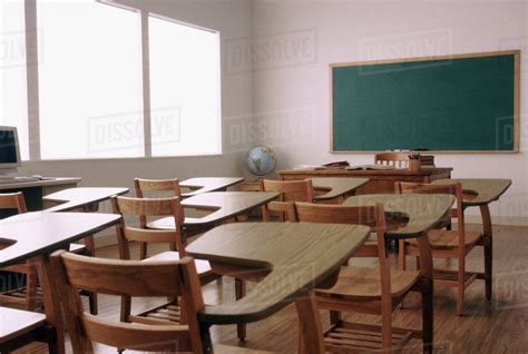 Empty desk in elementary school classroom - Stock Photo - Dissolve