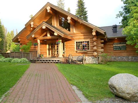 a log house with large rocks and grass