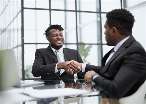 Premium Photo | Shot of two young business men shaking hands in a modern office