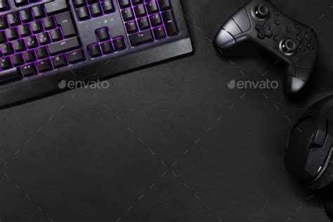 Purple lit keyboard by game controller and mouse Stock Photo by kjekol